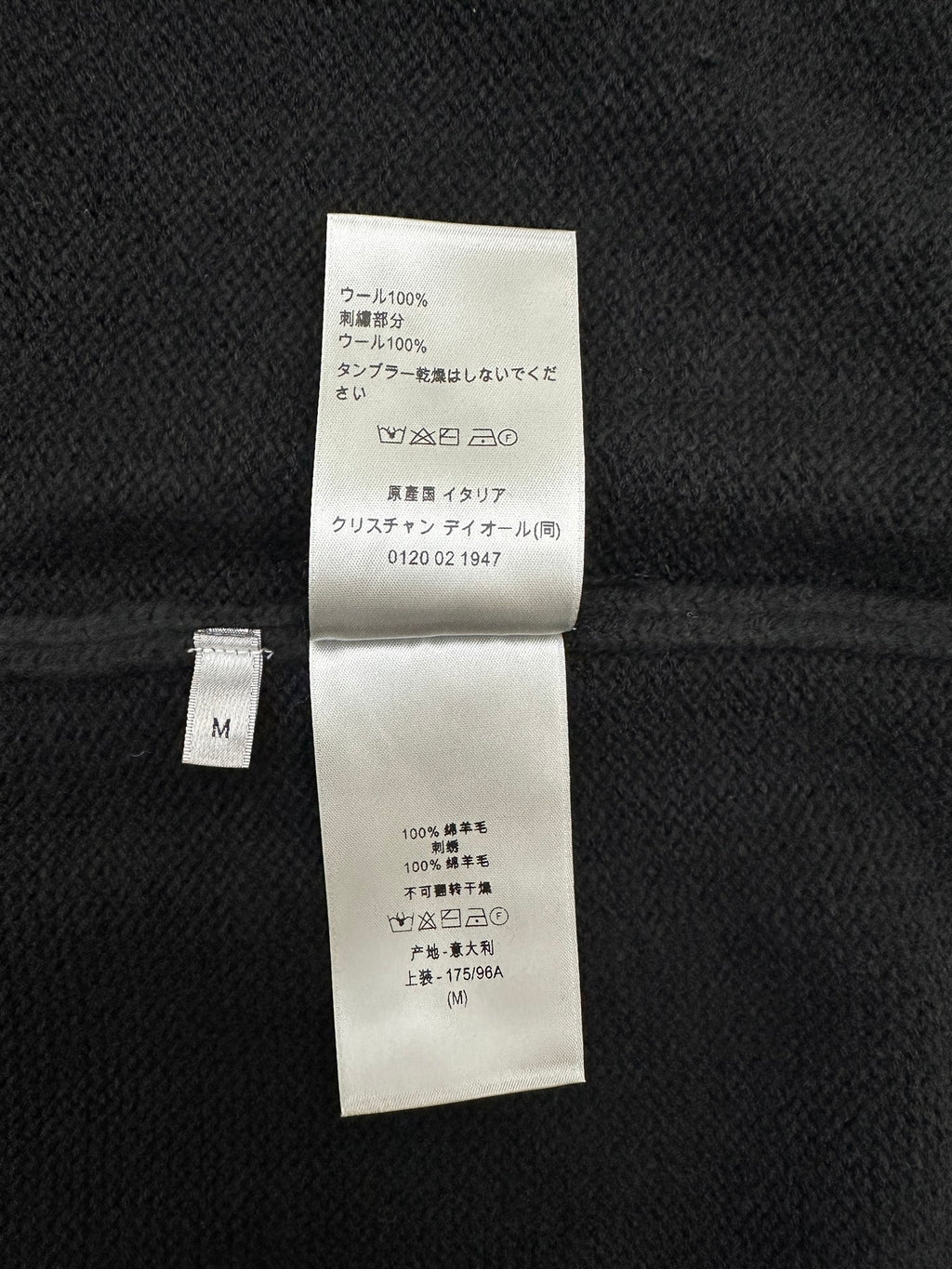 Dark knit jacket interior care label with composition details and size M