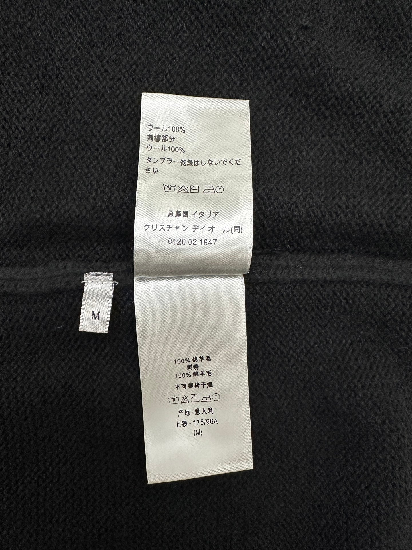 Dark knit jacket interior care label with composition details and size M