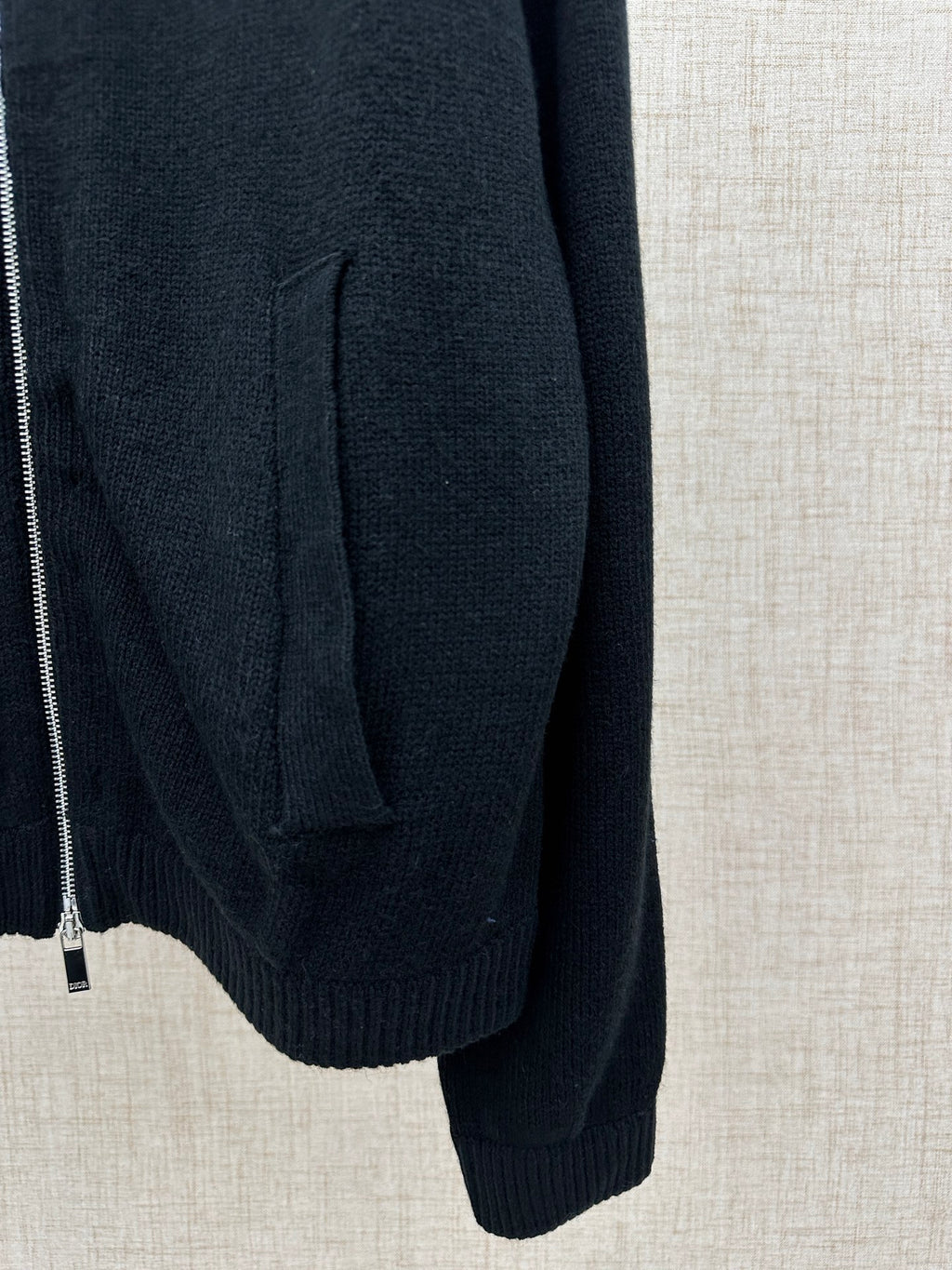 Dark knit jacket side with pocket seam and ribbed cuff