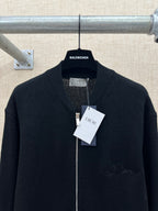 Dark zip-up knit jacket with ribbed stand collar and front hang tags