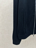 Dark knit jacket side view with ribbed hem and zipper at the edge
