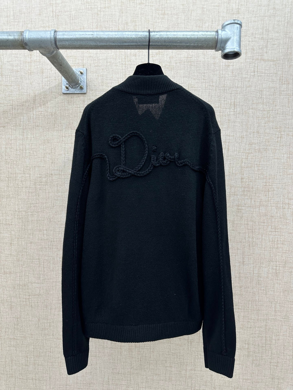 Zip-up knit jacket back view with ribbed high collar and raised logo embroidery