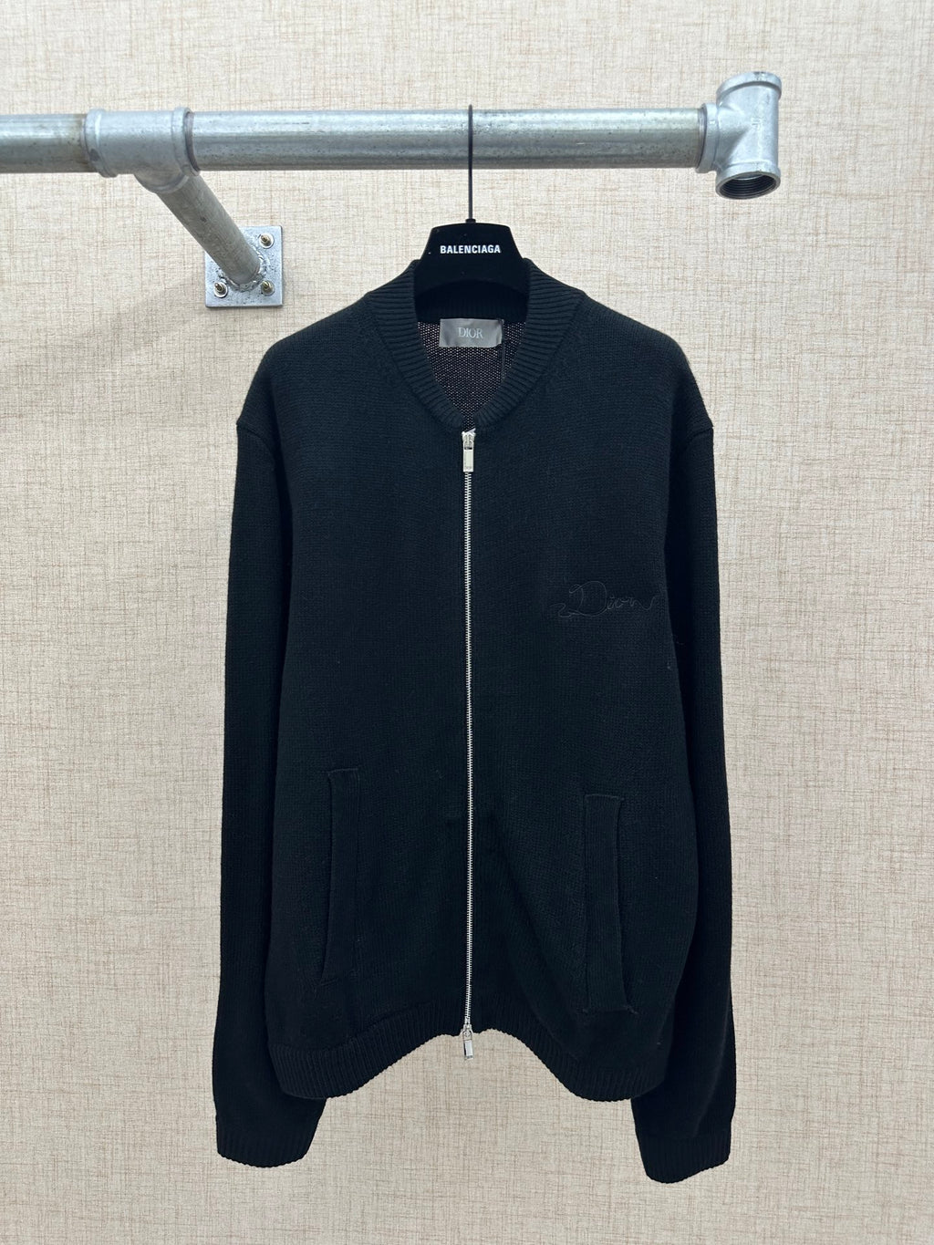 Zip-up knit jacket in dark color with stand collar, front zipper, and two side pockets