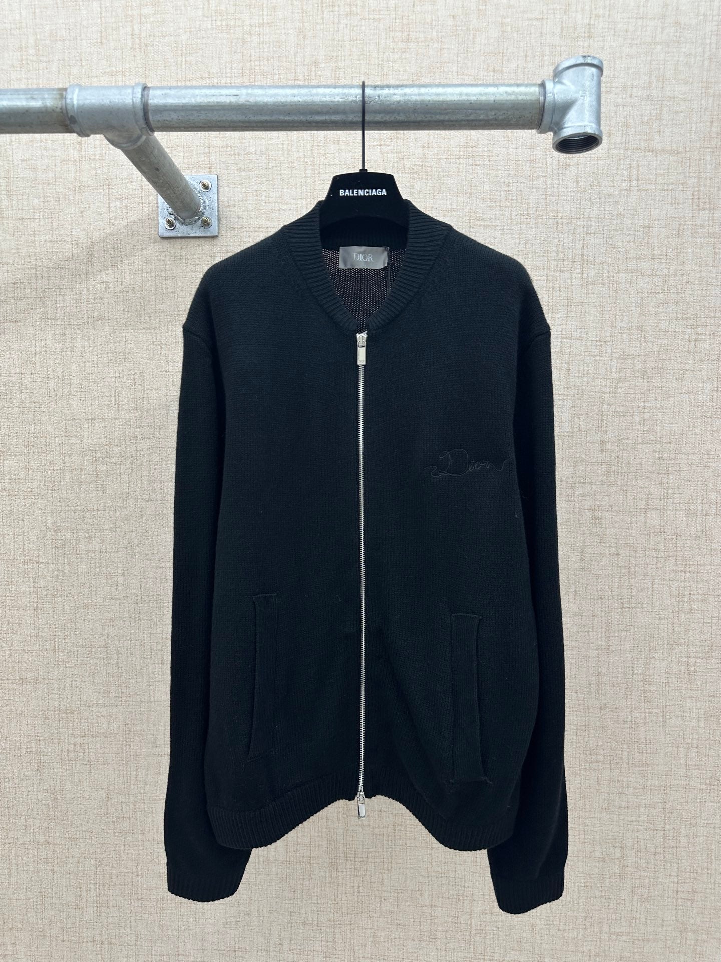 Zip-up knit jacket in dark color with stand collar, front zipper, and two side pockets