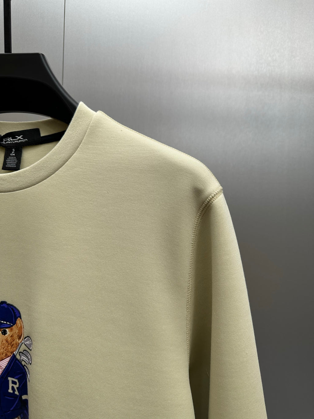 Cream sweatshirt shoulder and crew neckline with teddy graphic detail