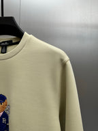 Cream sweatshirt shoulder and crew neckline with teddy graphic detail