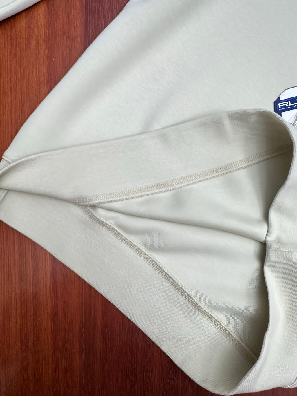 Cream sweatshirt sleeve with inner seam stitching visible