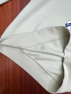 Cream sweatshirt sleeve with inner seam stitching visible