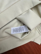 Cream sweatshirt with care label visible at interior neck seam