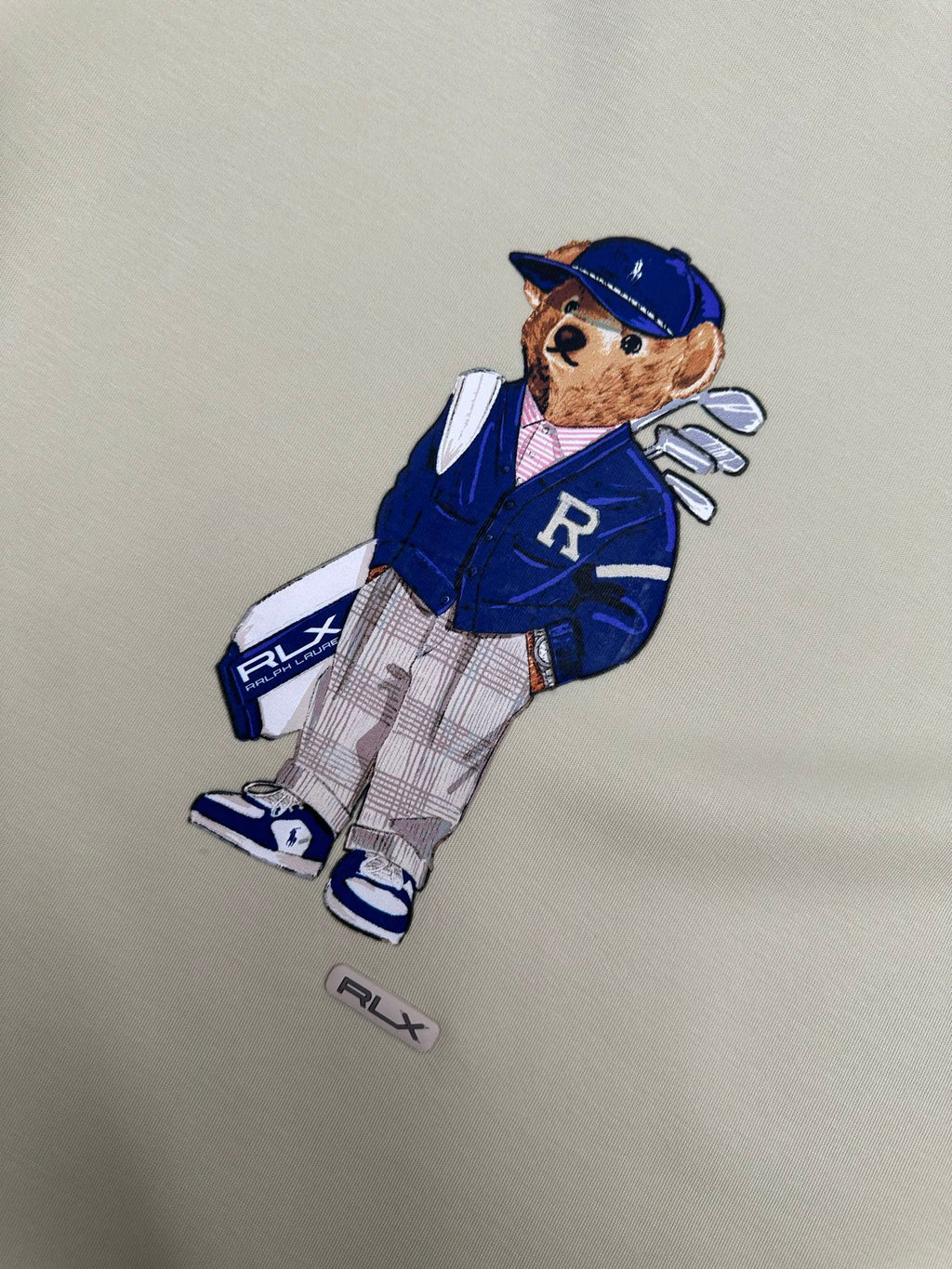 Cream sweatshirt with teddy-bear graphic and small RLX logo patch
