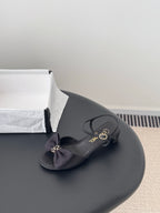 Dark bow sandal with Chanel-logo insole and adjustable strap