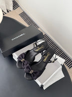Dark bow slingback sandals with gold-tone hardware, with Chanel box nearby