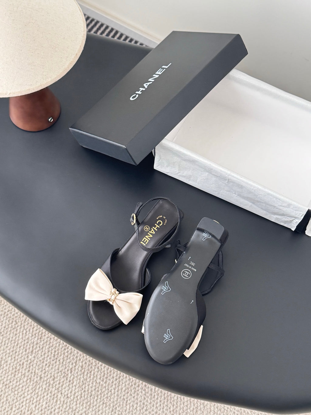 Black bow slingback sandals with gold-tone buckles and Chanel logo on footbeds