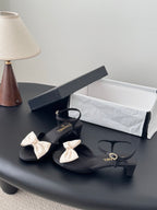Black bow sandals with ankle strap and gold-tone hardware, Chanel printed insoles
