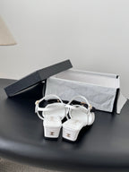 Chanel bow-strap sandals in white with black knot and gold buckles, kitten heel