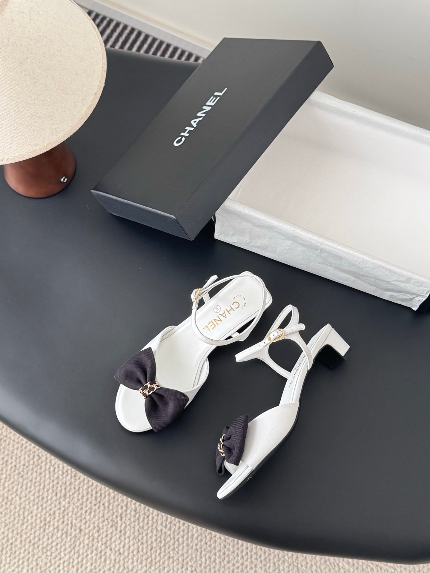 Chanel bow sandals in white with black satin bow and gold chain buckle