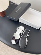Chanel bow sandals in white with black bow accents and gold buckle, open toe