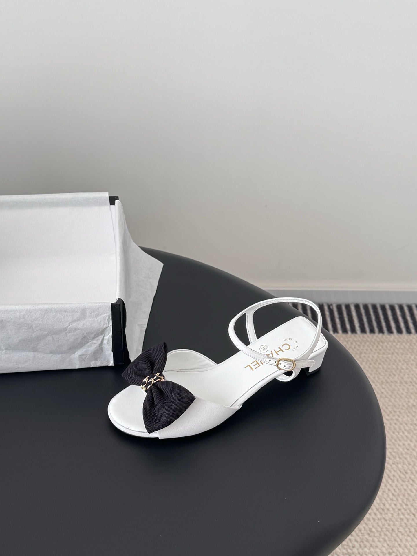 Chanel bow mule sandals in white with black bow and gold buckle strap
