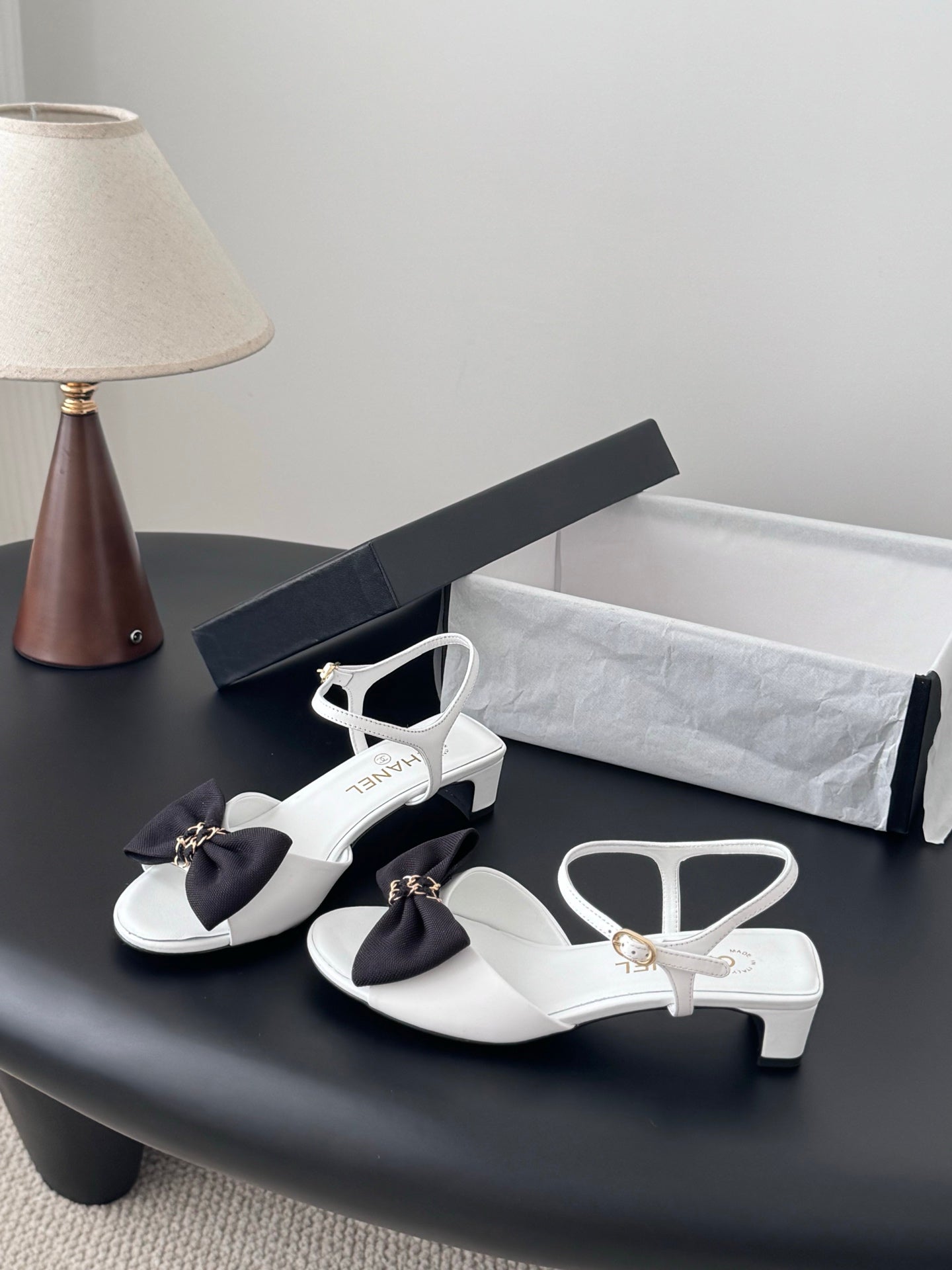 White slingback sandals with dark bow, gold-tone hardware, low block heel