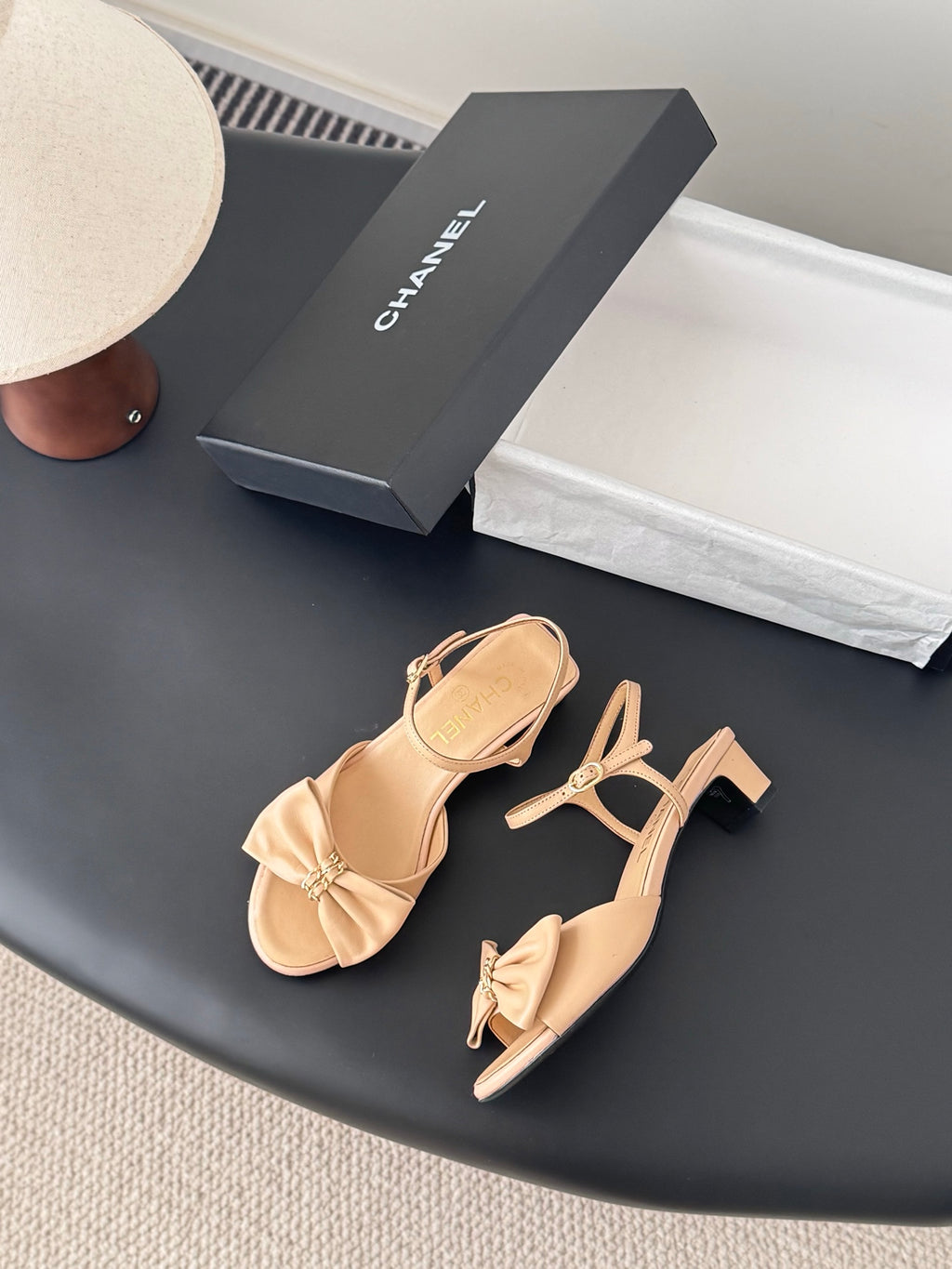 Pair of beige bow sandals with ankle strap and low block heel
