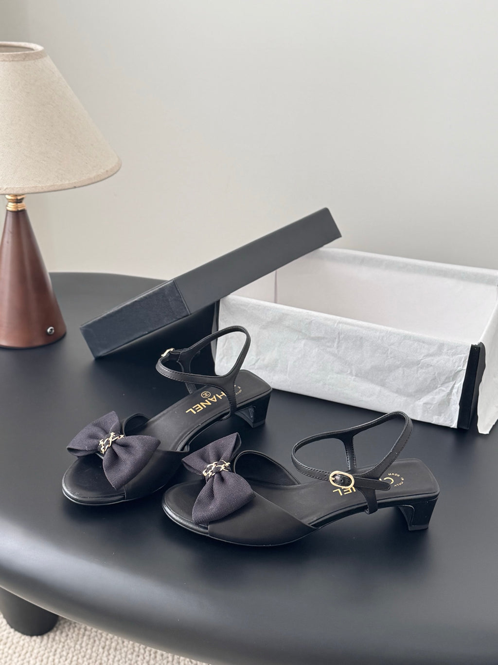 Chanel women's dark heeled sandals with ankle strap and bow detail, gold hardware