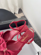 Pink strappy sandals with bow on vamp and ankle strap, showing footbed and logo