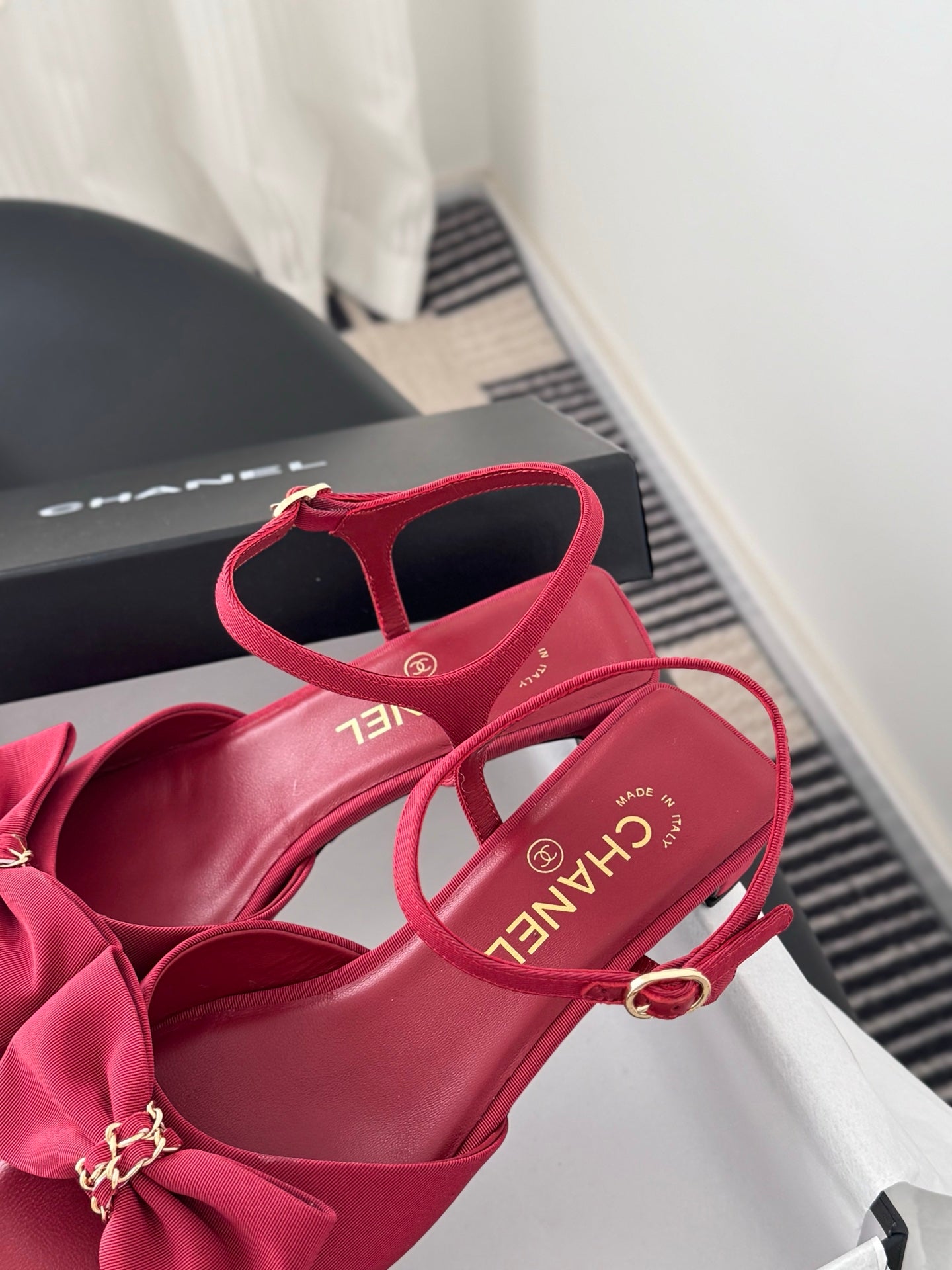 Pink strappy sandals with bow on vamp and ankle strap, showing footbed and logo