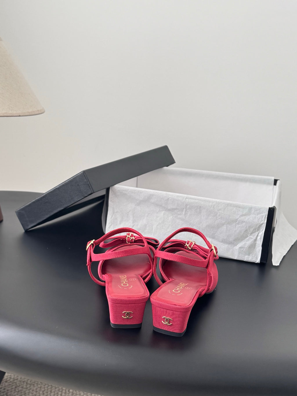 Pair of pink slingback sandals with ankle strap and block heel, bow accents