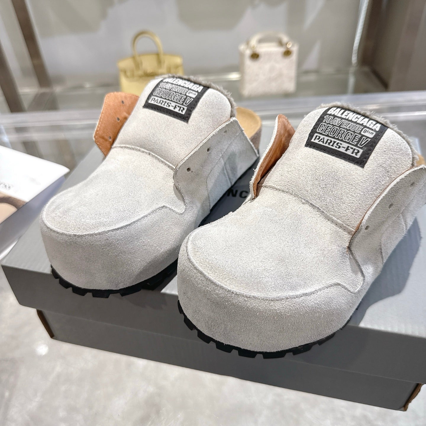 Balenciaga slip-on shoes in light gray suede, top/front view with branded collar labels