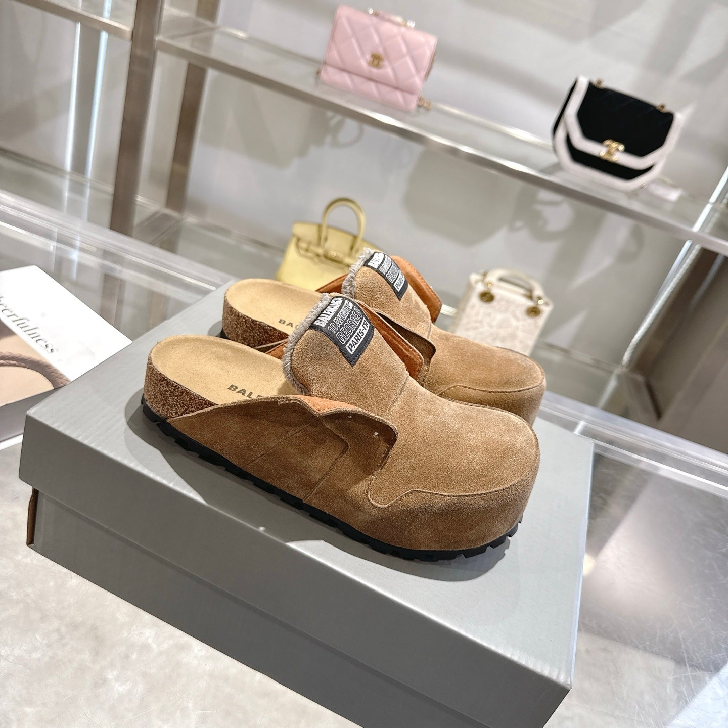 Balenciaga brown suede clogs with fur trim, black logo patch, and platform-style sole