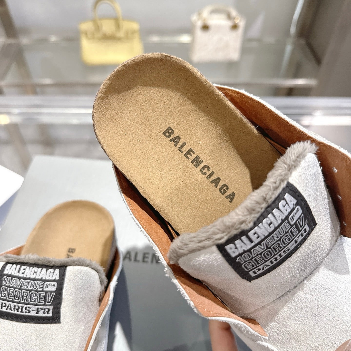 Balenciaga slip-on shoes close-up, shearling collar with BALENCIAGA logo patch and tan insole