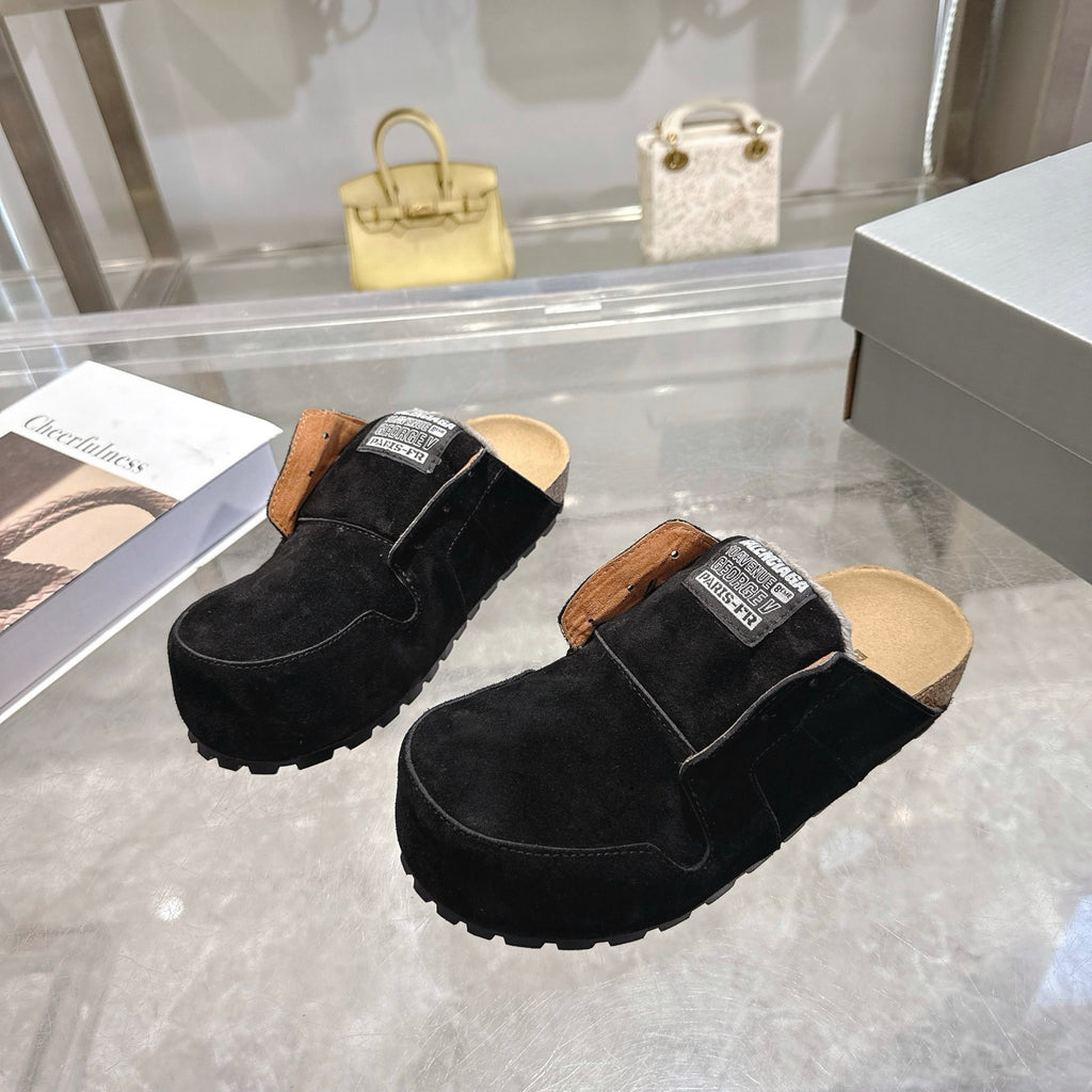Black suede slip-on mules with tan lining, fur collar, and Balenciaga logo patches
