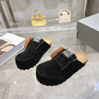 Black suede slip-on mules with tan lining, fur collar, and Balenciaga logo patches
