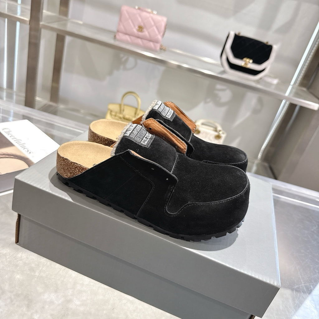 Black suede slip-on mules with tan lining, fur collar, and treaded outsole