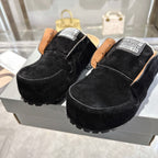 Pair of black suede slip-on mules with Balenciaga logo patches and treaded soles
