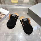 Black slip-on mule shoes with tan lining and Balenciaga logo patch