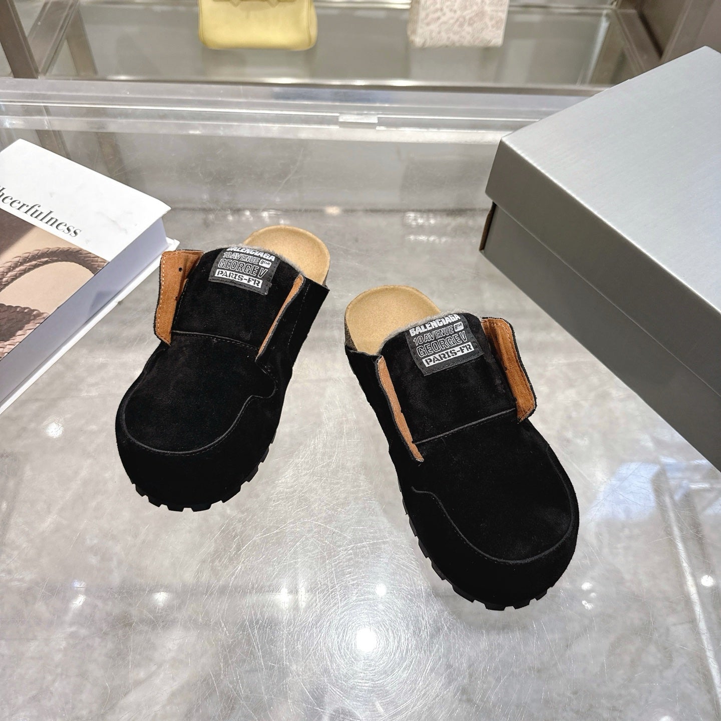 Black slip-on mule shoes with tan lining and Balenciaga logo patch