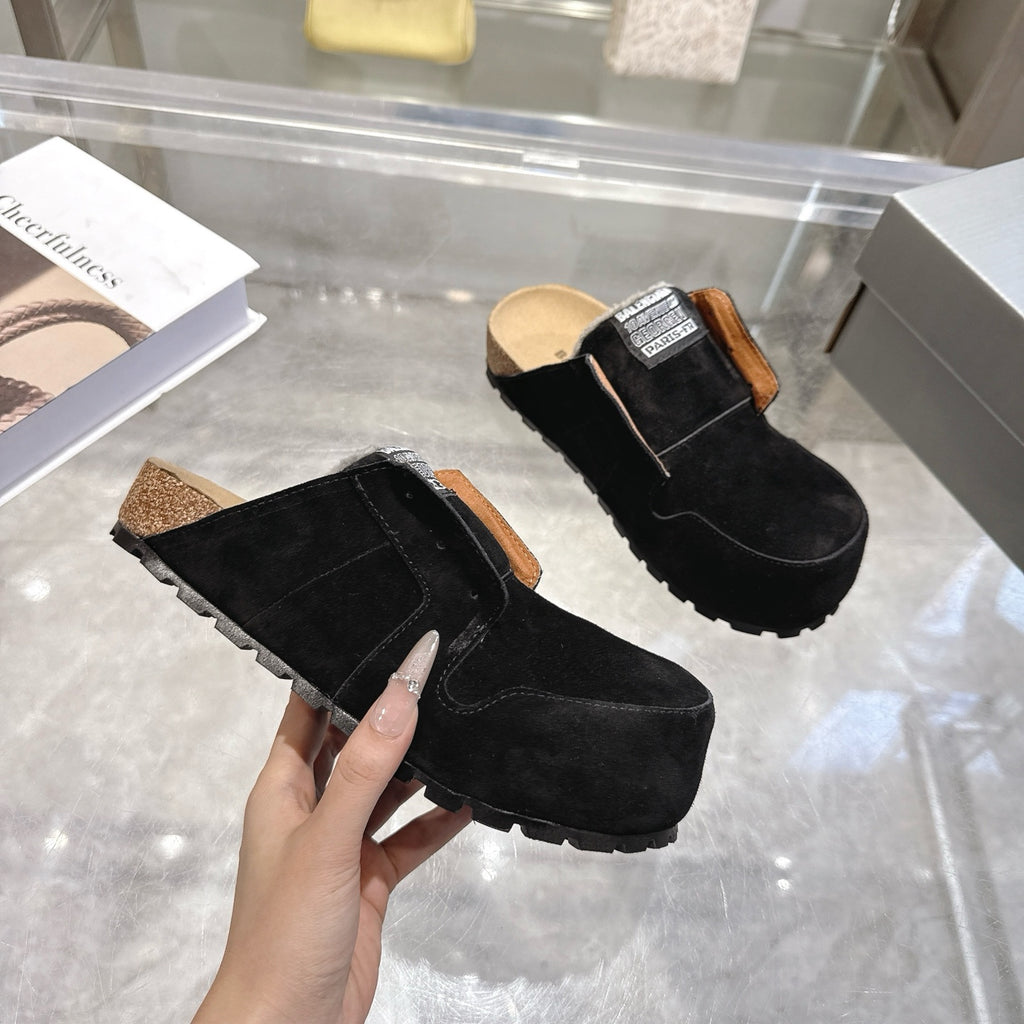 Black suede slip-on mules with brown edge trim and chunky outsole