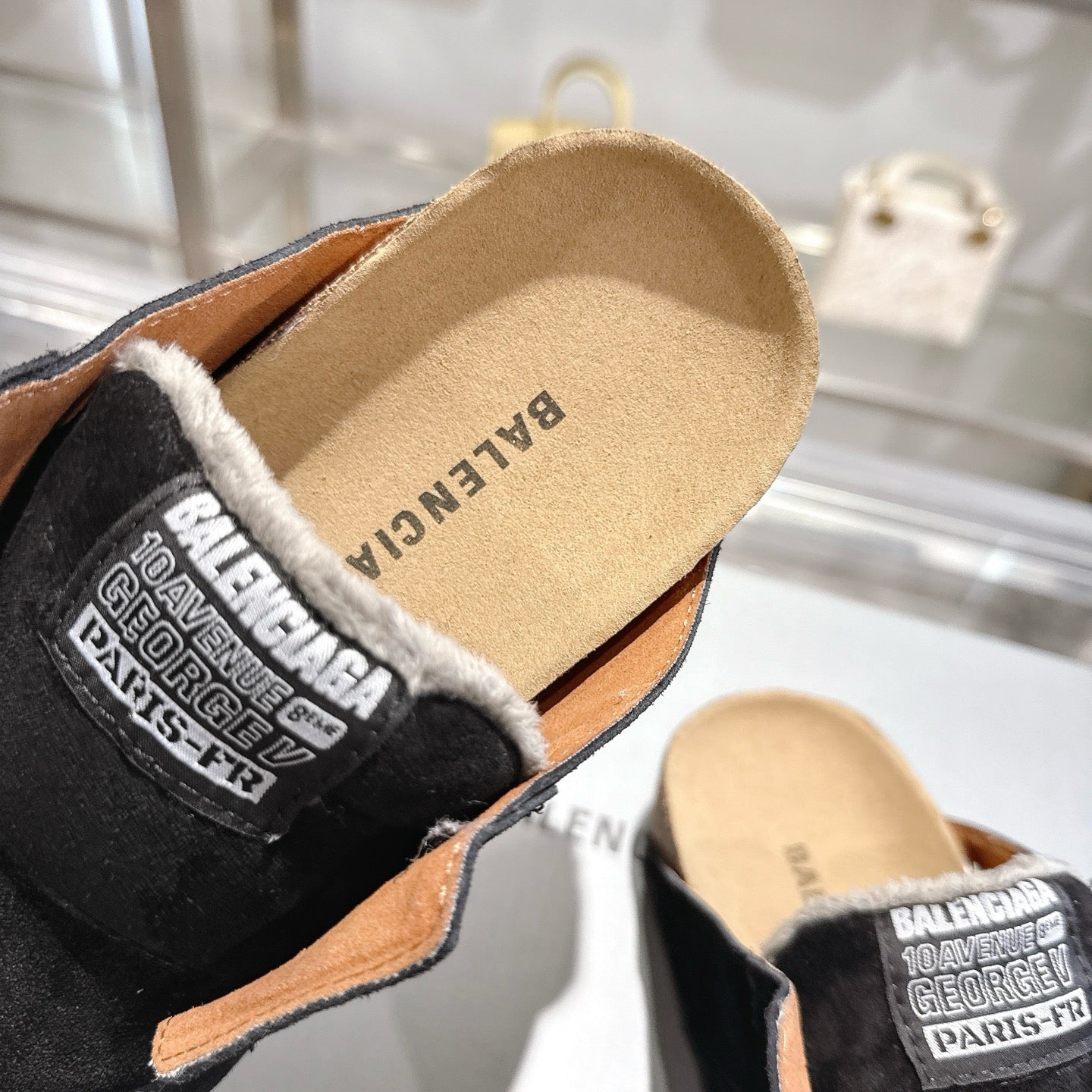 Balenciaga slide mule with tan footbed, black upper, and fur-trim collar