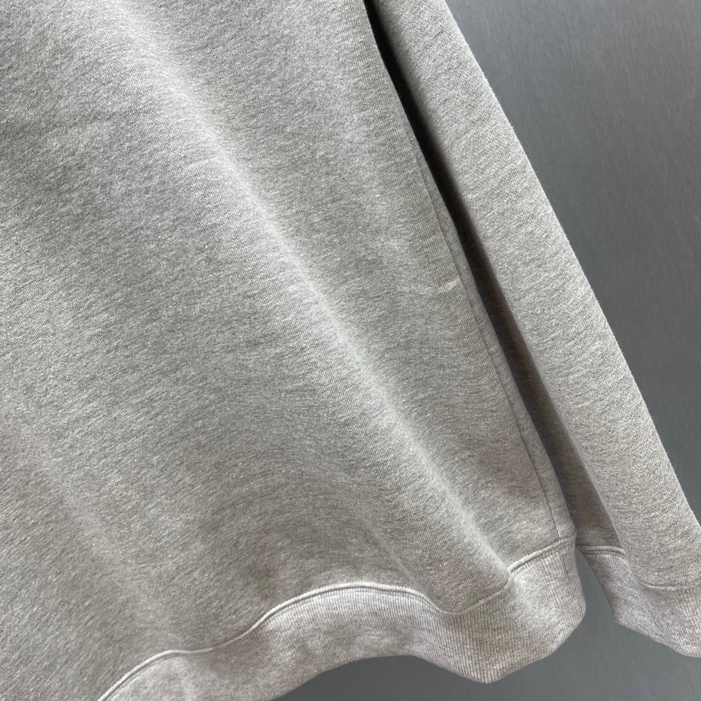 Light gray Gucci sweatshirt sleeve and lower side hem view