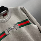 Light gray Gucci sweatshirt showing striped logo and embroidered double-G detail