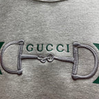Light gray Gucci sweatshirt close-up of embroidered double-G on stripe panel