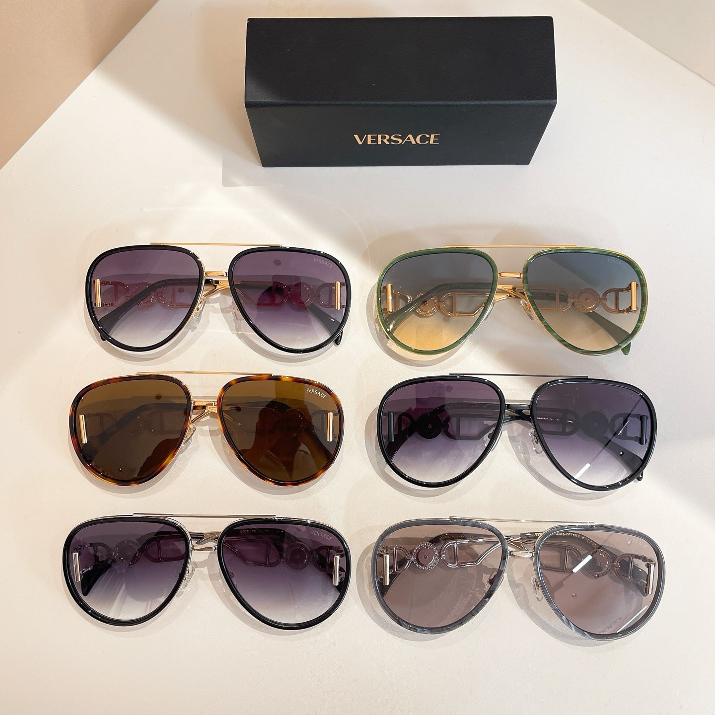 Versace sunglasses display with mixed frames and tinted lenses on a tabletop