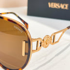 Versace sunglasses close-up with gold frame details and dark-tinted lenses