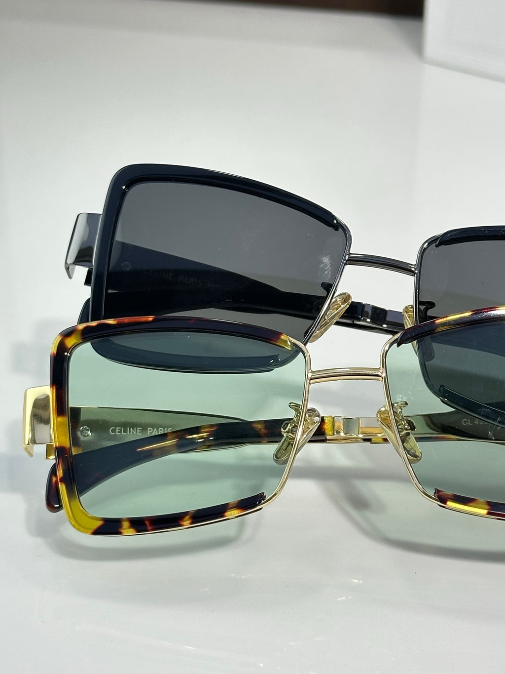 Close-up square sunglasses with gold-tone accents and dark lenses