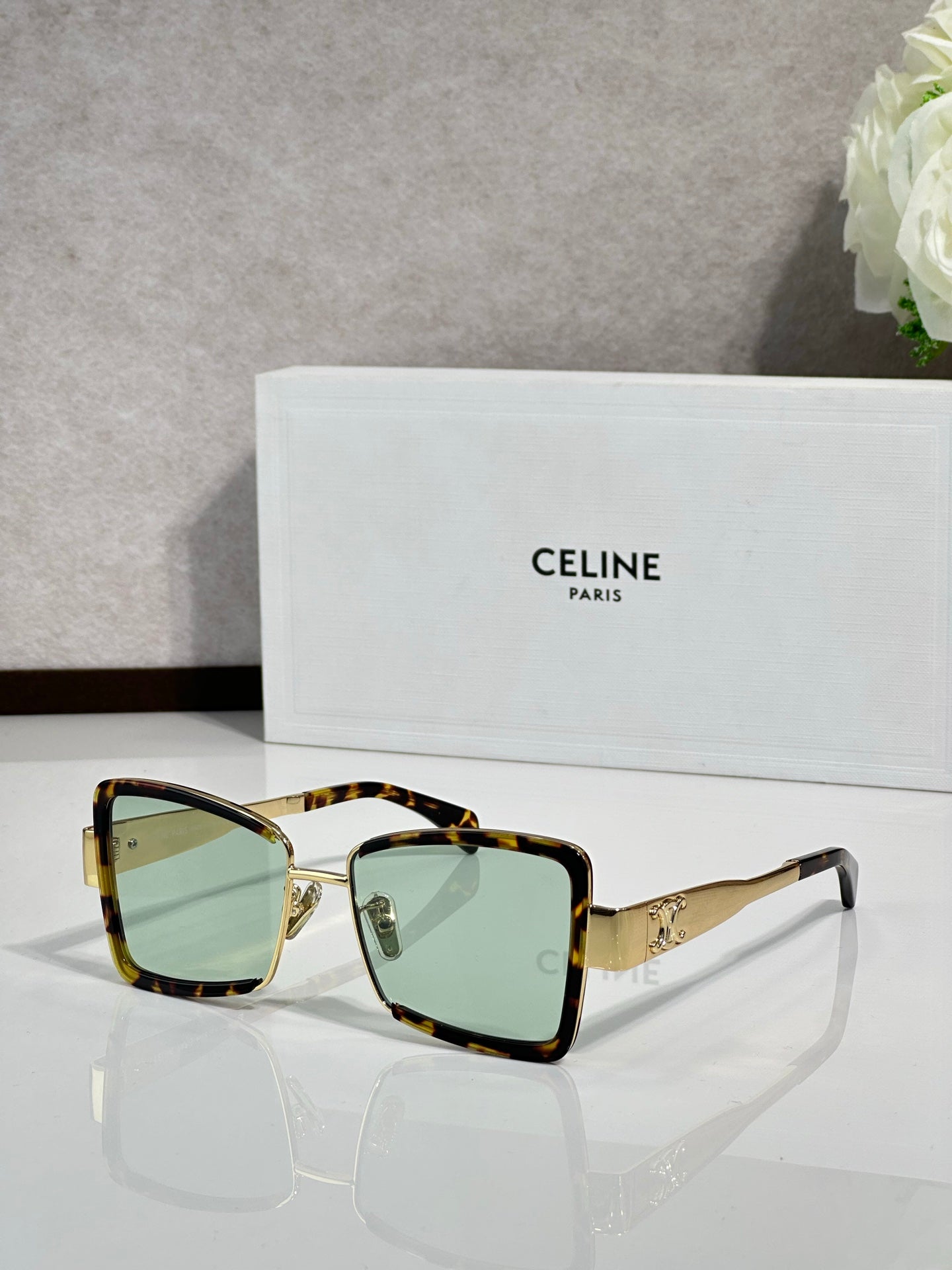Square sunglasses with tortoiseshell frame and green-tinted lenses
