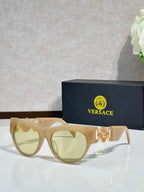 Sunglasses, gold frames with gold emblem, tinted light lenses, cat-eye style