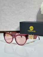 Sunglasses, red frames with gold emblem, tinted light lenses, cat-eye style