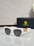 Sunglasses, white frames with gold emblem, tinted dark lenses, cat-eye style