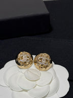 Gold-tone round stud earrings with sparkling crystal logo-style motif